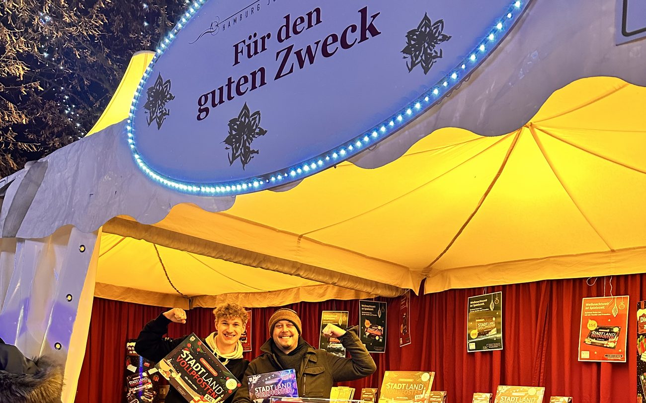 Zwei strahlende Helfer am Stand Für den guten Zweck, Stand-Nr. 47, mit Spielen von Stadt Land Vollpfosten